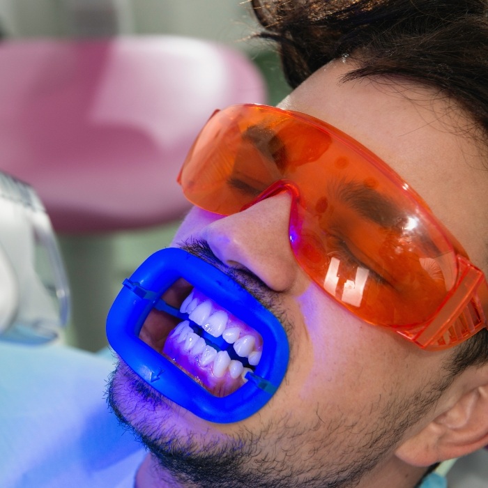 Man in dental chair getting professional teeth whitening