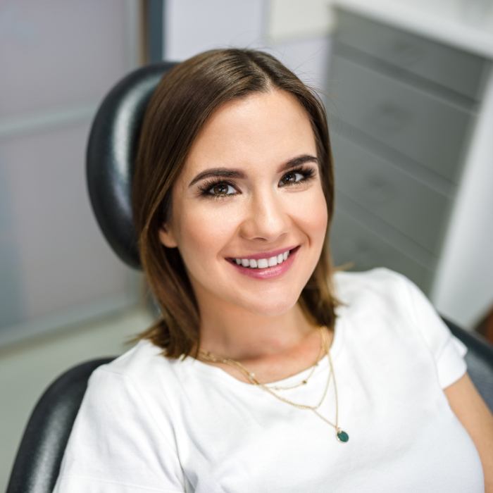 Woman smiling in dental chair before dental checkup and teeth cleaning in Plattsburgh