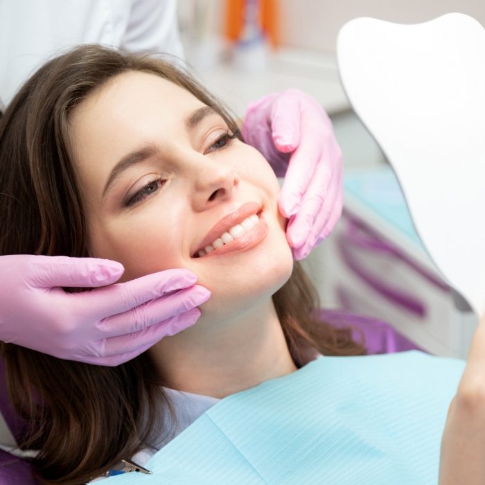 Dental patient looking at her smile in mirror