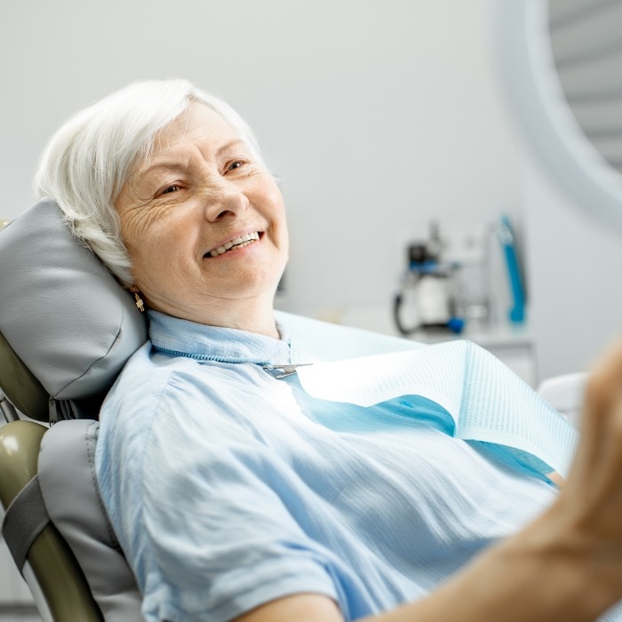 Dental patient admiring her smile in a mirror