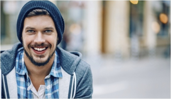 Young man in blue beanie smiling