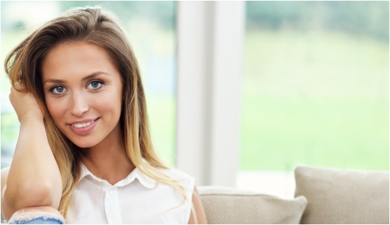 Woman smiling with her hand on the back of her head