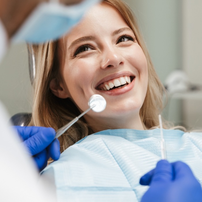 Woman in dental chair smiling at her dentist