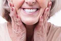 Woman smiling brightly and touching her face