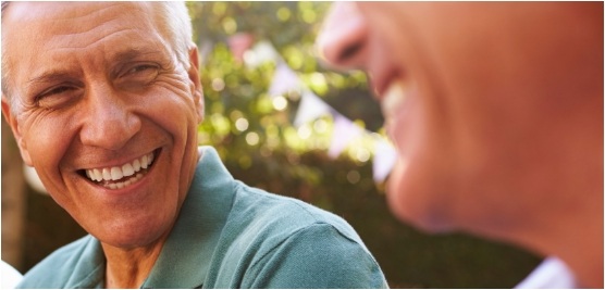 Man laughing with friends outdoors