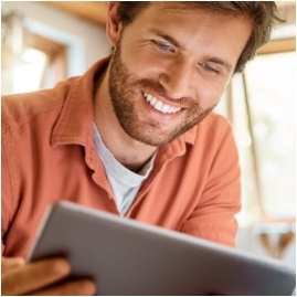 Smiling man looking at a screen