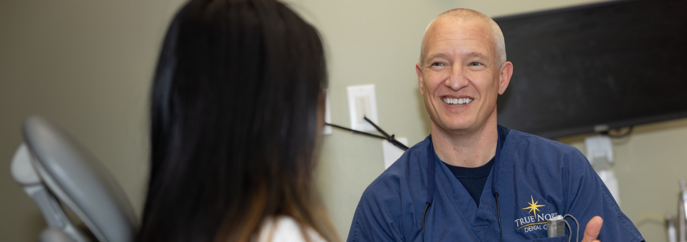 Doctor Heins laughing with a dental patient