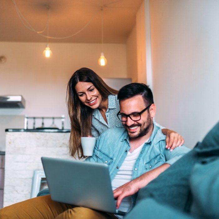 Man and woman looking on laptop for dentist reviews in Plattsburgh